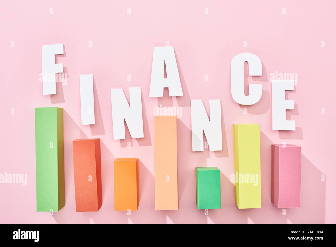 Vista superiore della finanza iscrizione con un grafico a colori su sfondo rosa Foto Stock
