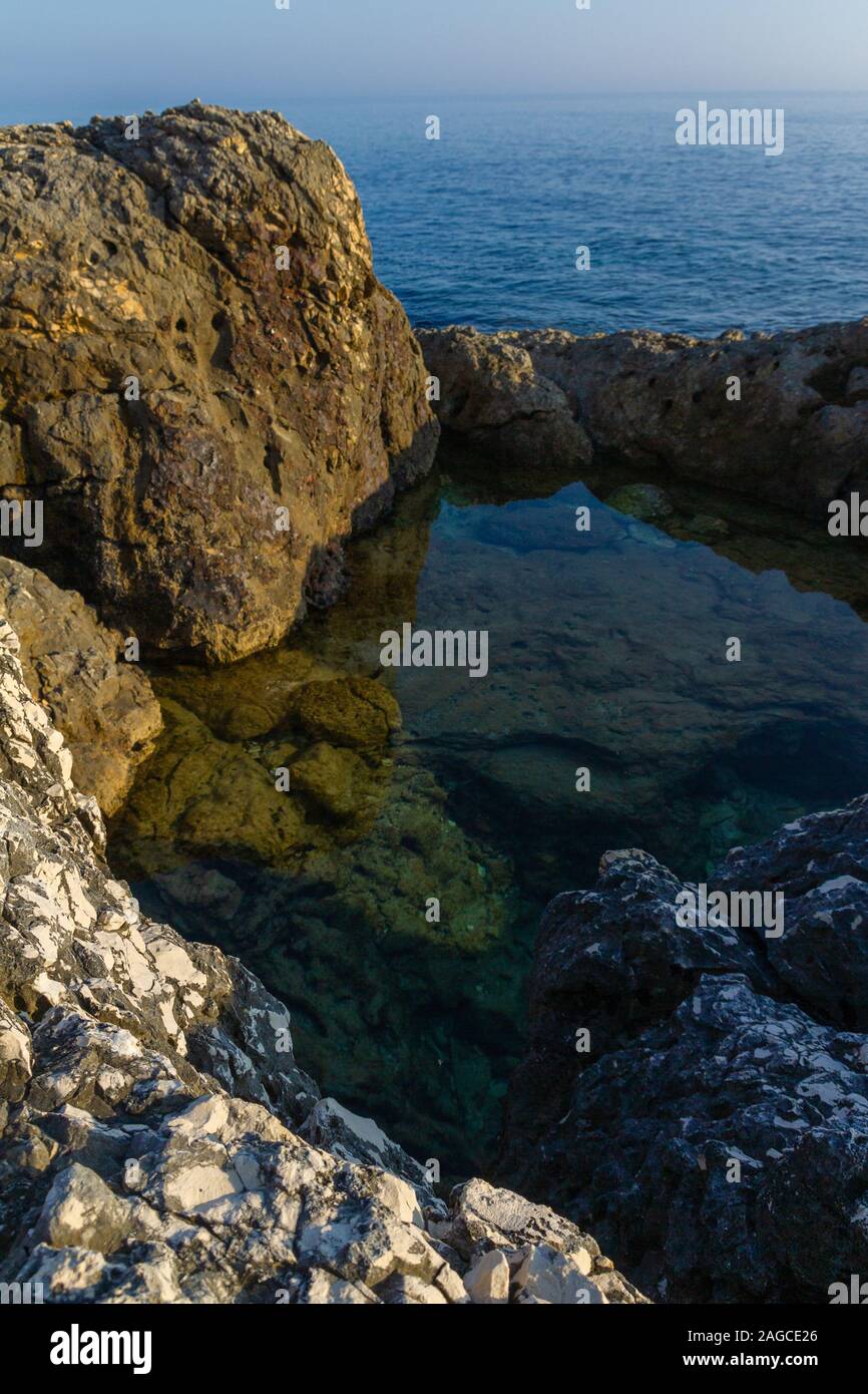 Immagine verticale di un piccolo lago formato all'interno delle rocce della costa di Kamenjak in Istria, Croazia Foto Stock