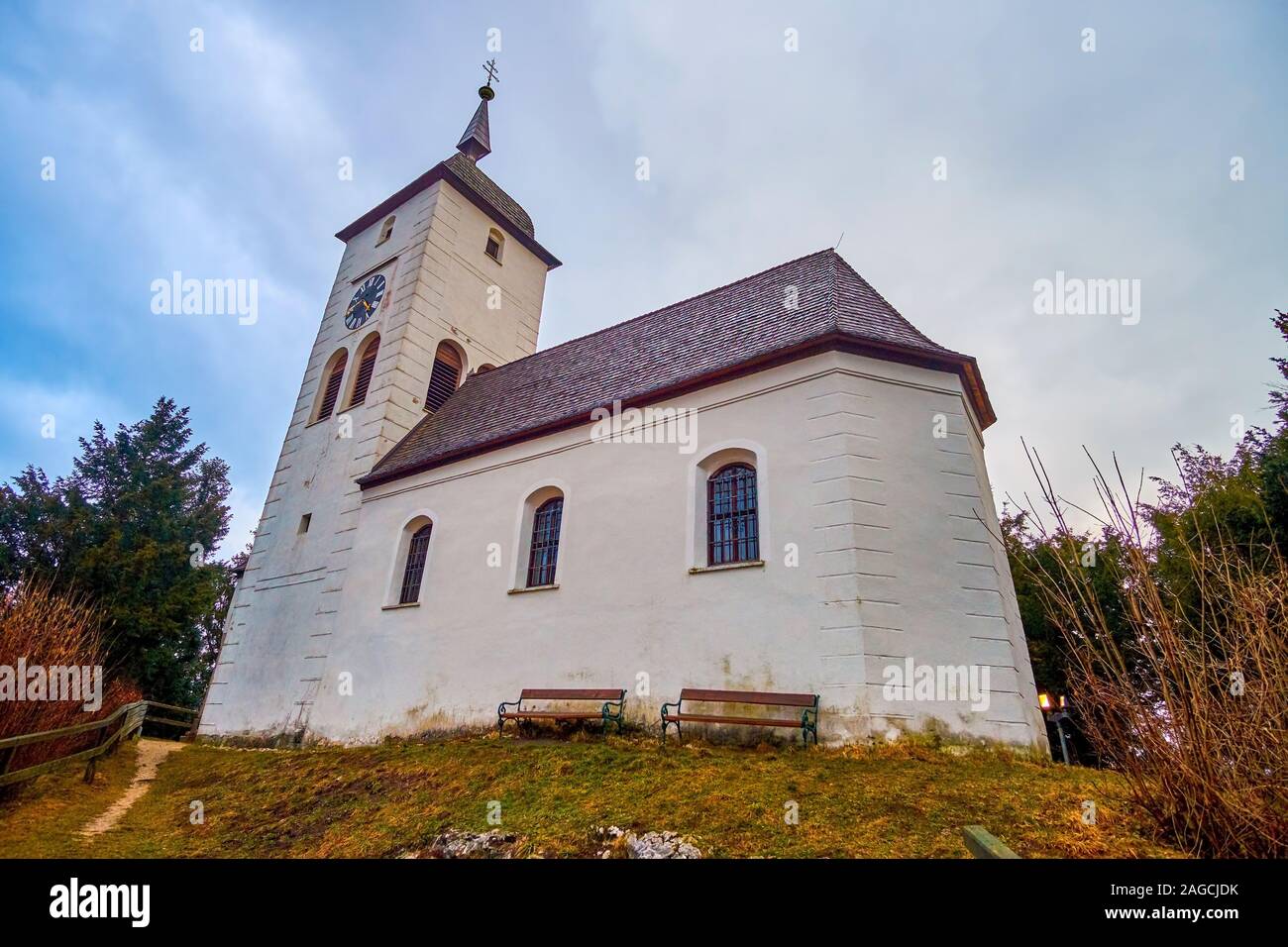 La bellissima medievale Johannesberg Cappella con pareti bianche è la più notevole punto di riferimento di Traunkirchen Village, situato sulla cima della roccia, Aust Foto Stock