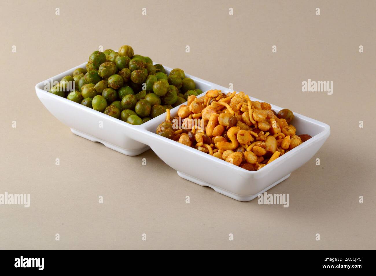 Indian snack: miscela e fritti speziati piselli verdi {chatpata mataró} nella piastra bianca. Foto Stock