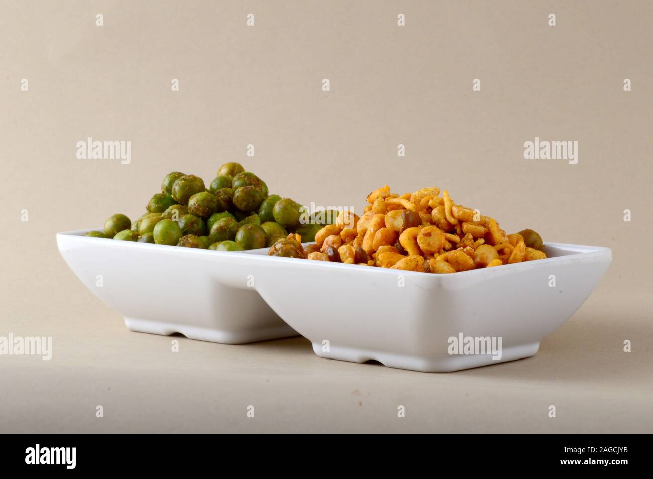 Indian snack: miscela e fritti speziati piselli verdi {chatpata mataró} nella piastra bianca. Foto Stock