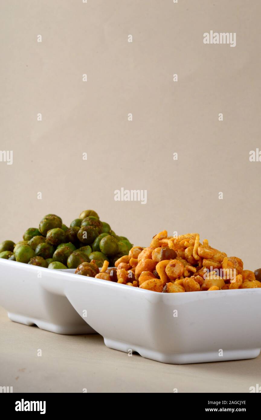 Indian snack: miscela e fritti speziati piselli verdi {chatpata mataró} nella piastra bianca. Foto Stock
