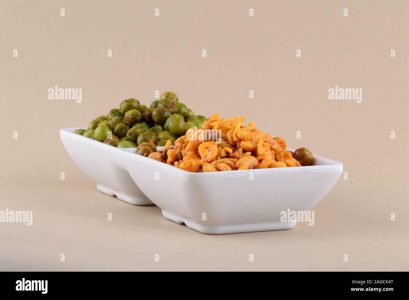 Indian snack: miscela e fritti speziati piselli verdi {chatpata mataró} nella piastra bianca. Foto Stock