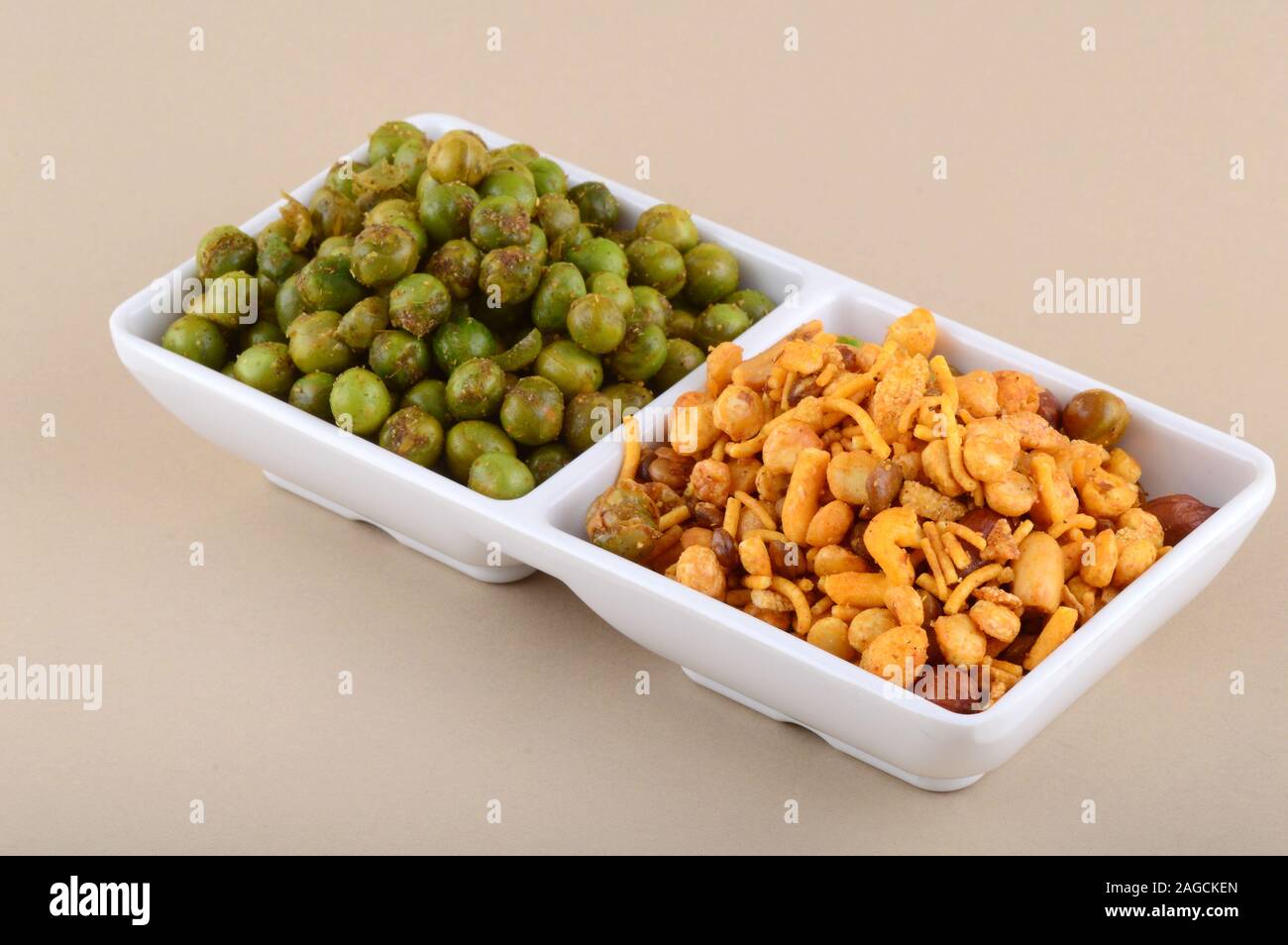 Indian snack: miscela e fritti speziati piselli verdi {chatpata mataró} nella piastra bianca. Foto Stock