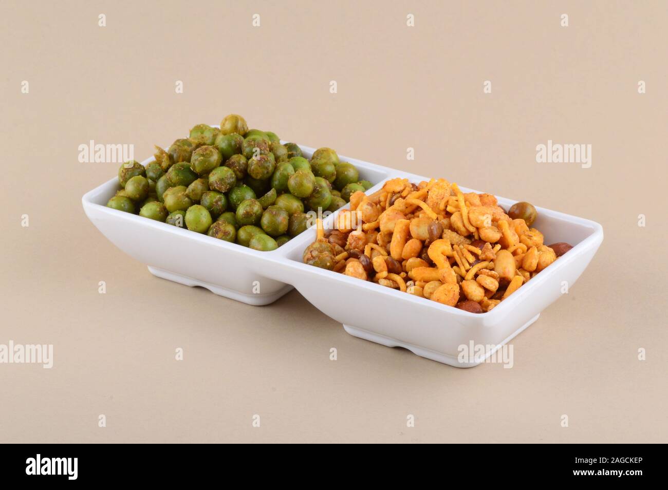 Indian snack: miscela e fritti speziati piselli verdi {chatpata mataró} nella piastra bianca. Foto Stock