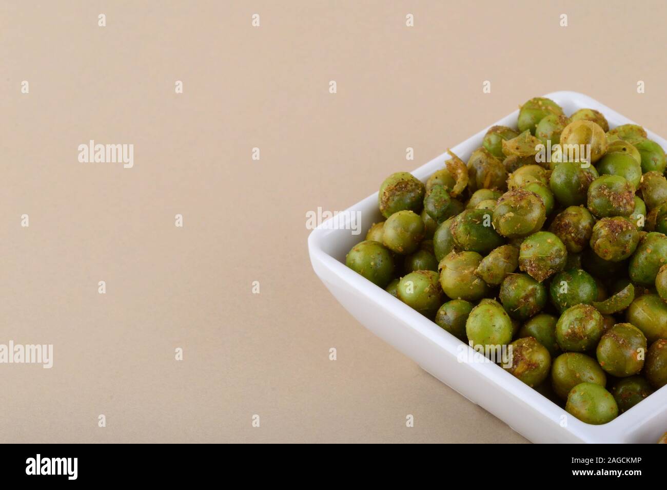 Indian snack: miscela e fritti speziati piselli verdi {chatpata mataró} nella piastra bianca. Foto Stock