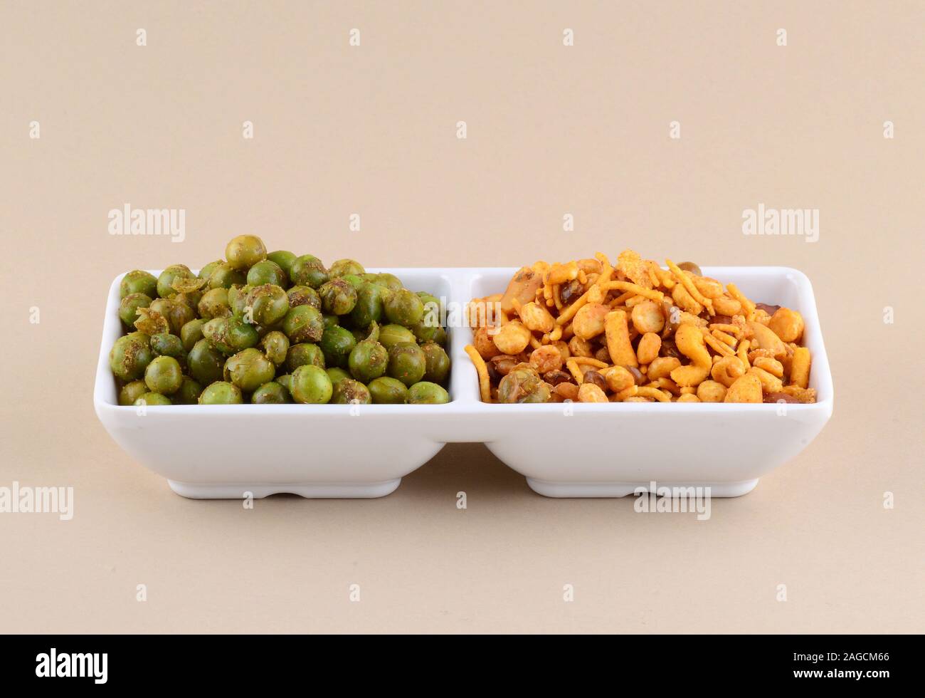 Indian snack: miscela e fritti speziati piselli verdi {chatpata mataró} nella piastra bianca. Foto Stock