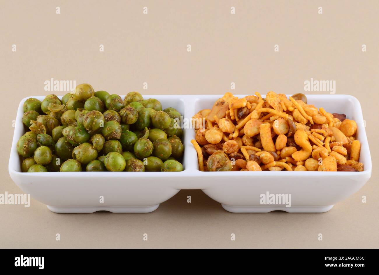 Indian snack: miscela e fritti speziati piselli verdi {chatpata mataró} nella piastra bianca. Foto Stock