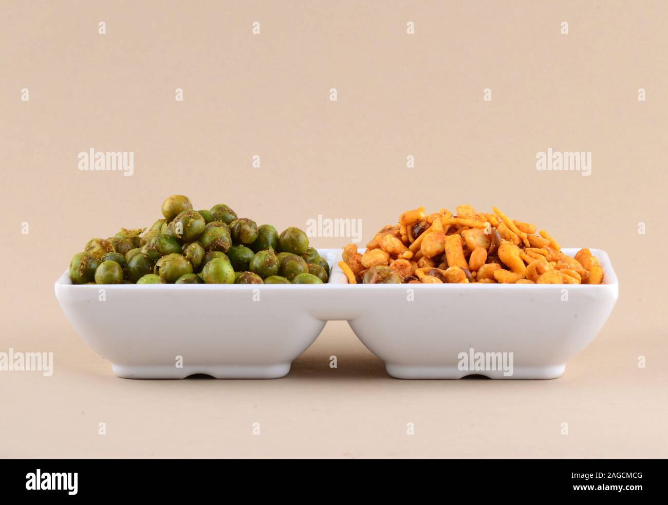 Indian snack: miscela e fritti speziati piselli verdi {chatpata mataró} nella piastra bianca. Foto Stock