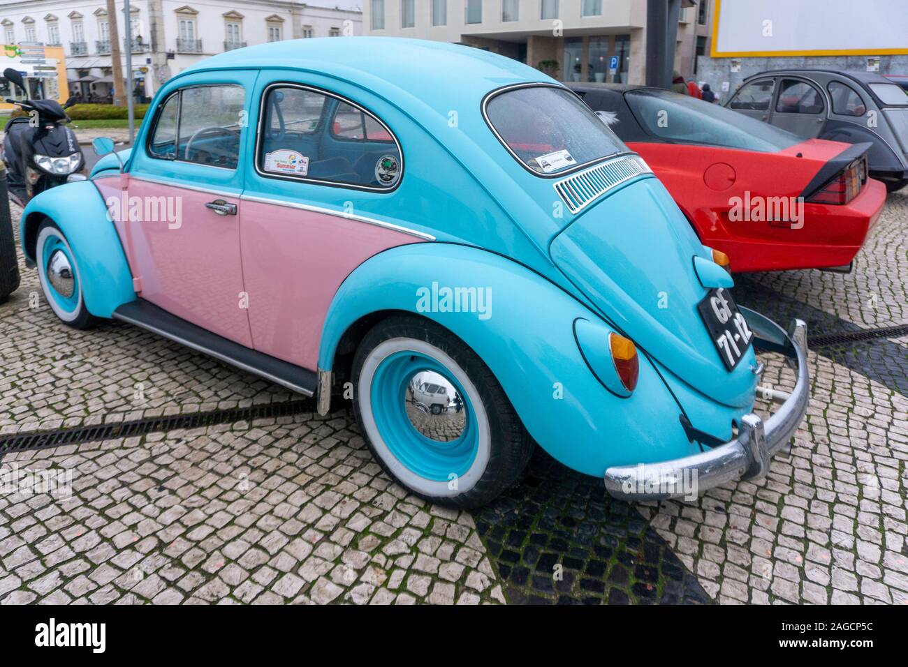 Faro, Portogallo. Una vettura di Volkswagen Beetle ricondizionata, colorata in blu e rosa, parcheggiata su ciottoli a Faro, in Portogallo Foto Stock