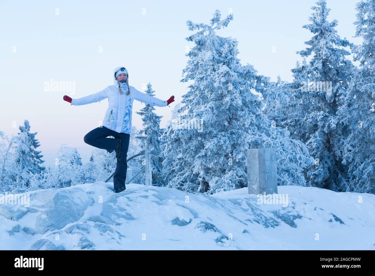 Donna fare yoga pone all'esterno in inverno a Koli Parco nazionale della Finlandia Foto Stock