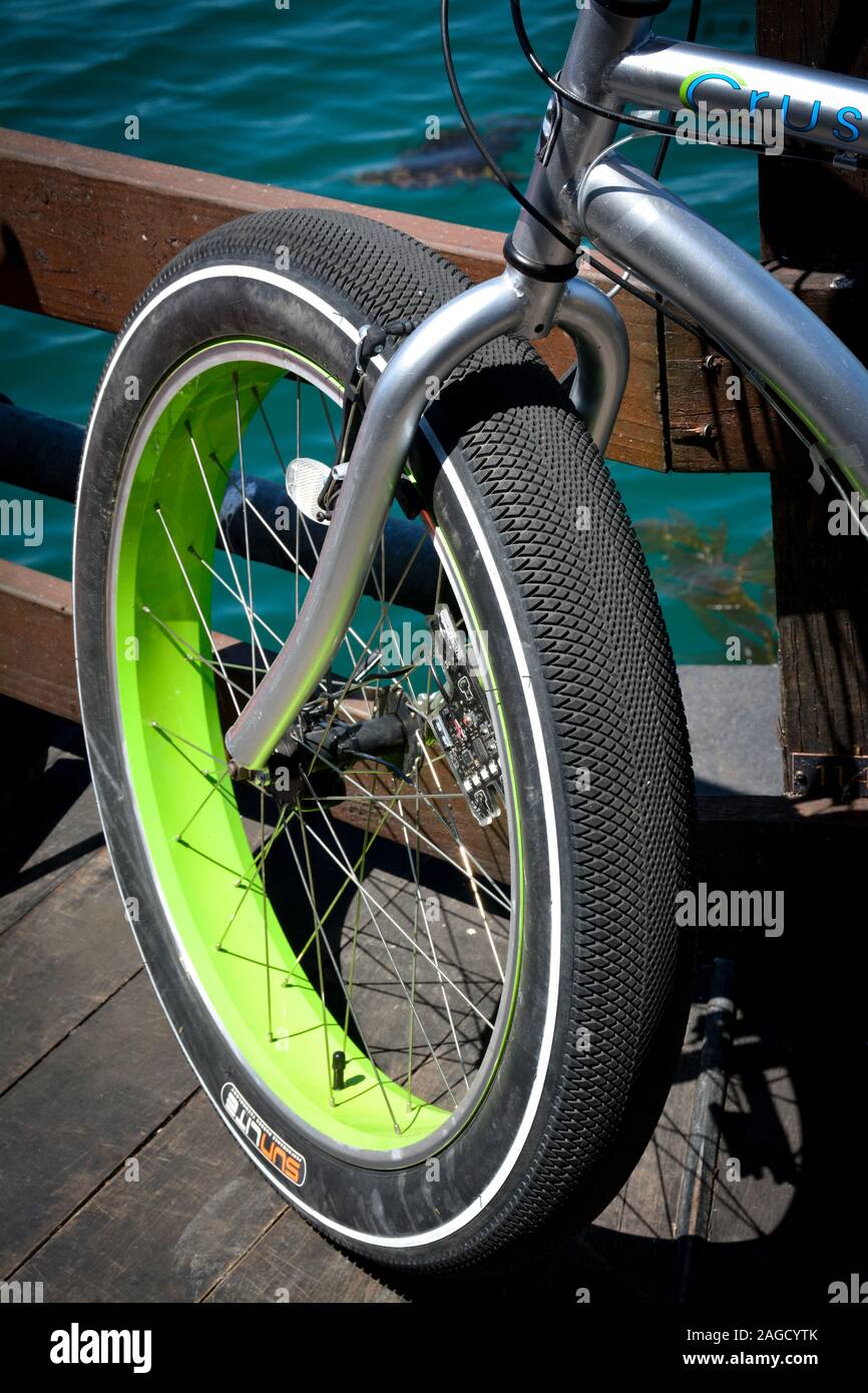 In prossimità della parte anteriore fat tire con calce cerchio verde sulla bicicletta elettrica, 'Monkey lectric', su un molo di Santa Barbara, CA Foto Stock