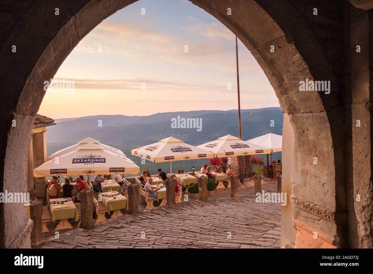 Sala da pranzo all'aperto al ristorante con vista delle montagne al tramonto, Montona, Istria, Croazia Foto Stock