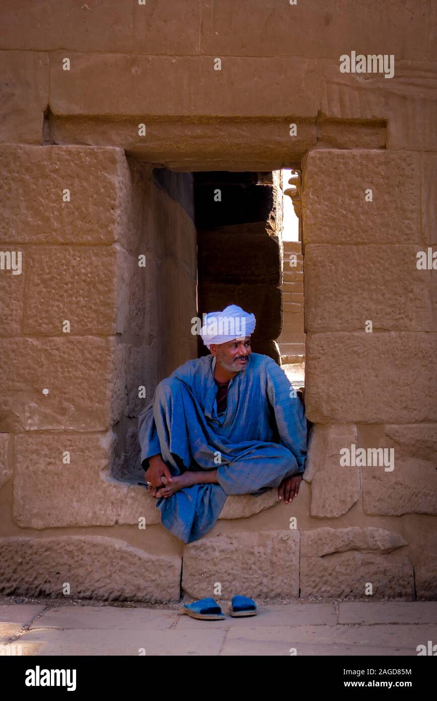 Novembre 2019, Egitto - uomo musulmano Egitto si siede nella finestra con le scarpe off Foto Stock
