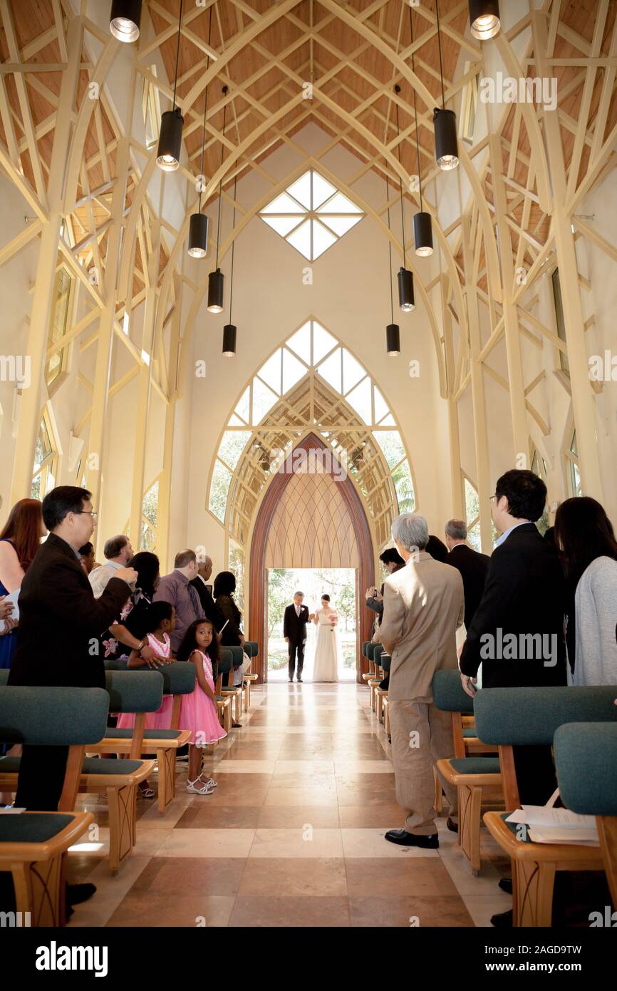 Padre sposa a piedi giù per la corsia in drammatico chiesa arcuata Foto Stock Padre sposa a piedi giù per la corsia in drammatico chiesa arcuata Foto Stock