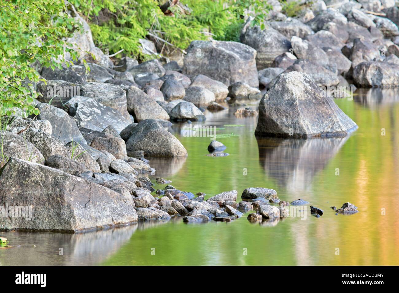 Pietre in acqua a Bjässjön durante la sera, a Indal, vicino Sundsvall, Svezia Foto Stock