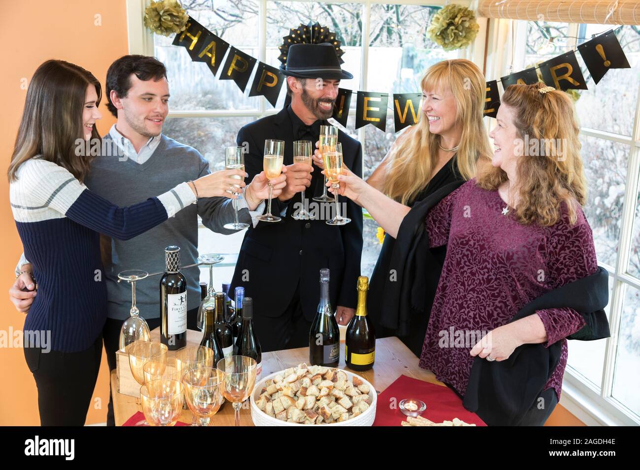 Un gruppo di persone fare un brindisi con champagne a una festa di Capodanno Foto Stock