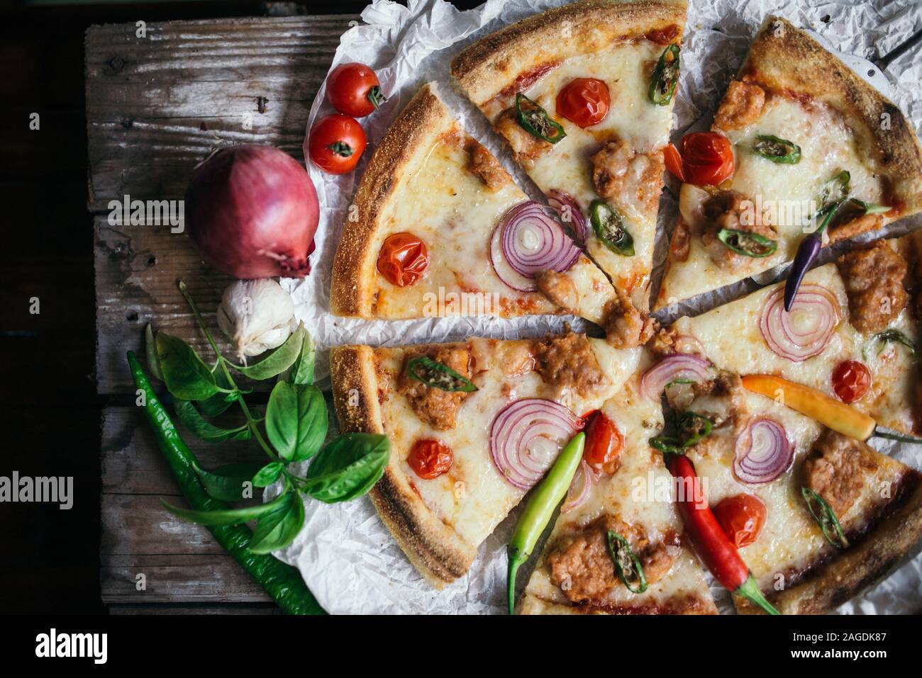 Creative pizza italiana con salsiccia per pizza e ciliegia nel ristorante. Foto Stock