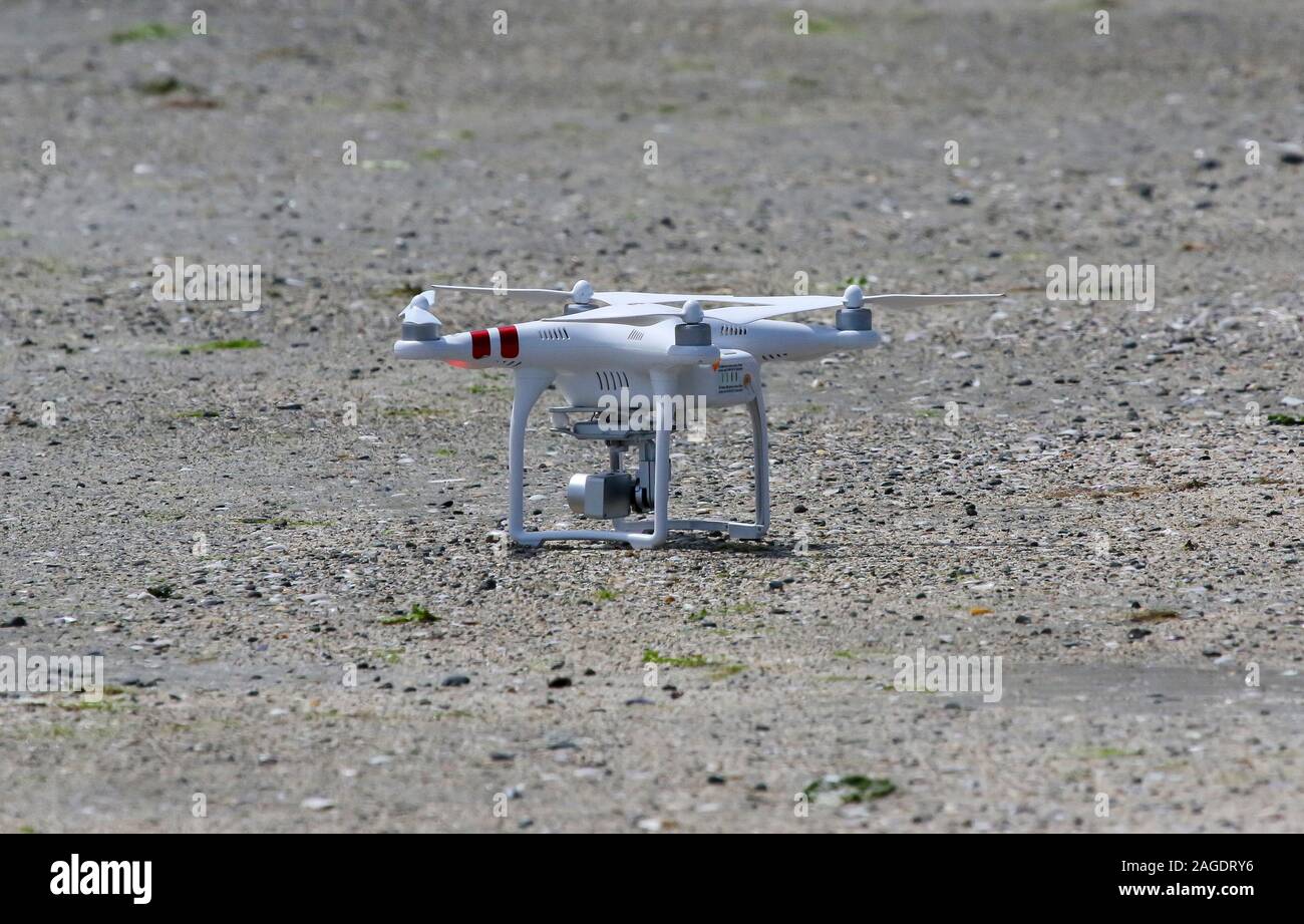 DJI drone - un DJI standard drone phantom parcheggiata su un disco riva sabbiosa prima del decollo. Foto Stock