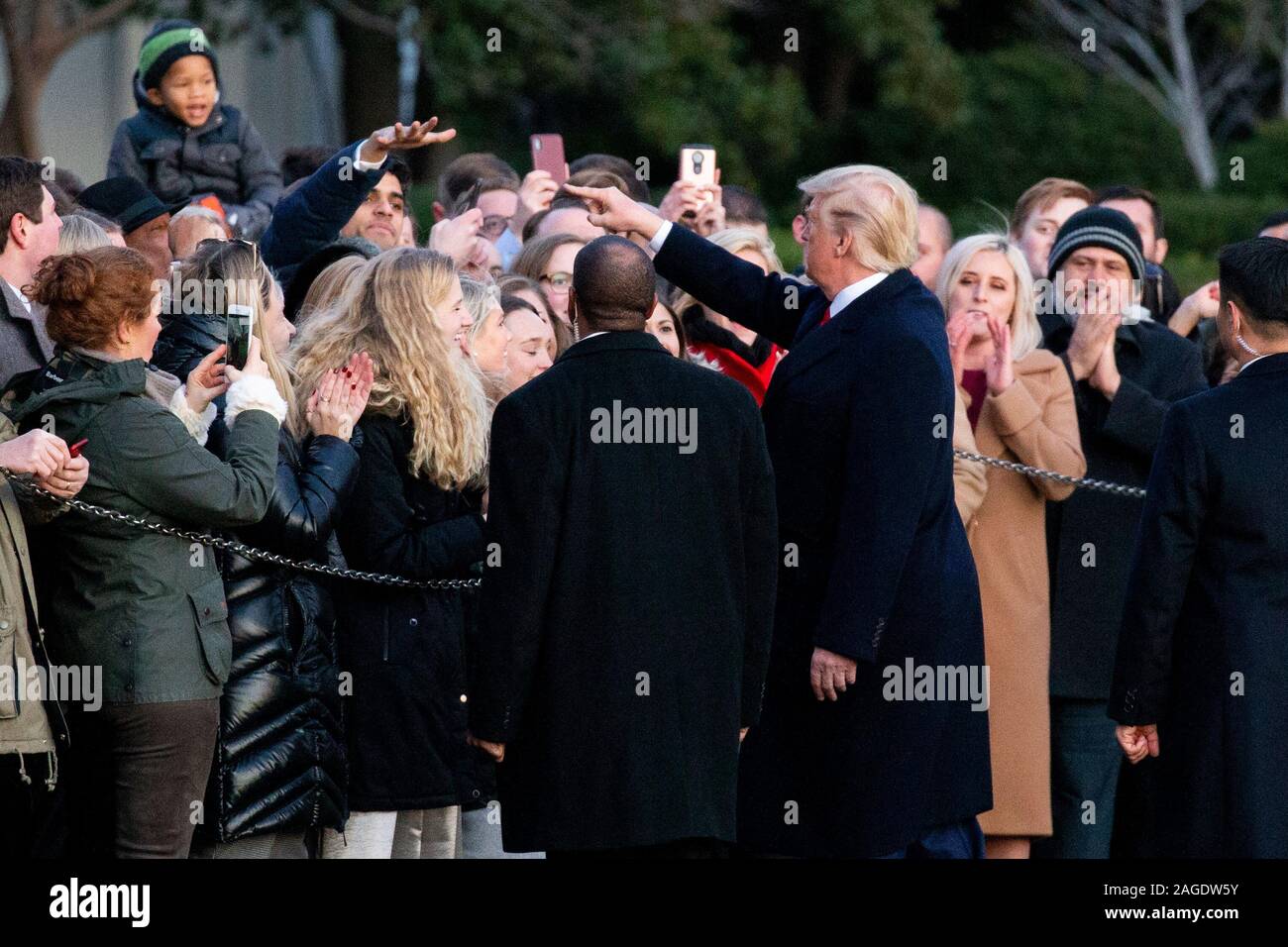 Il presidente statunitense Trump (R) che accoglie i visitatori alla Casa Bianca prima della partenza il South Lawn da Marine una rotta per Michigan per un rally; in Washington, DC, Stati Uniti d'America, 18 dicembre 2019. La Camera dei rappresentanti degli Stati Uniti è pronta a votare su due articoli di impeachment contro il presidente statunitense Trump, per abuso di potere e di ostruzione del Congresso. Se superato, Trump sarebbe diventato il terzo presidente americano della storia a essere impeached. Un impeachment porterebbe ad una prova nel senato degli Stati Uniti, dove due terzi del voto di approvazione potrebbe essere necessario al fine di rimuovere Trump come presidente.Credit: Michae Foto Stock