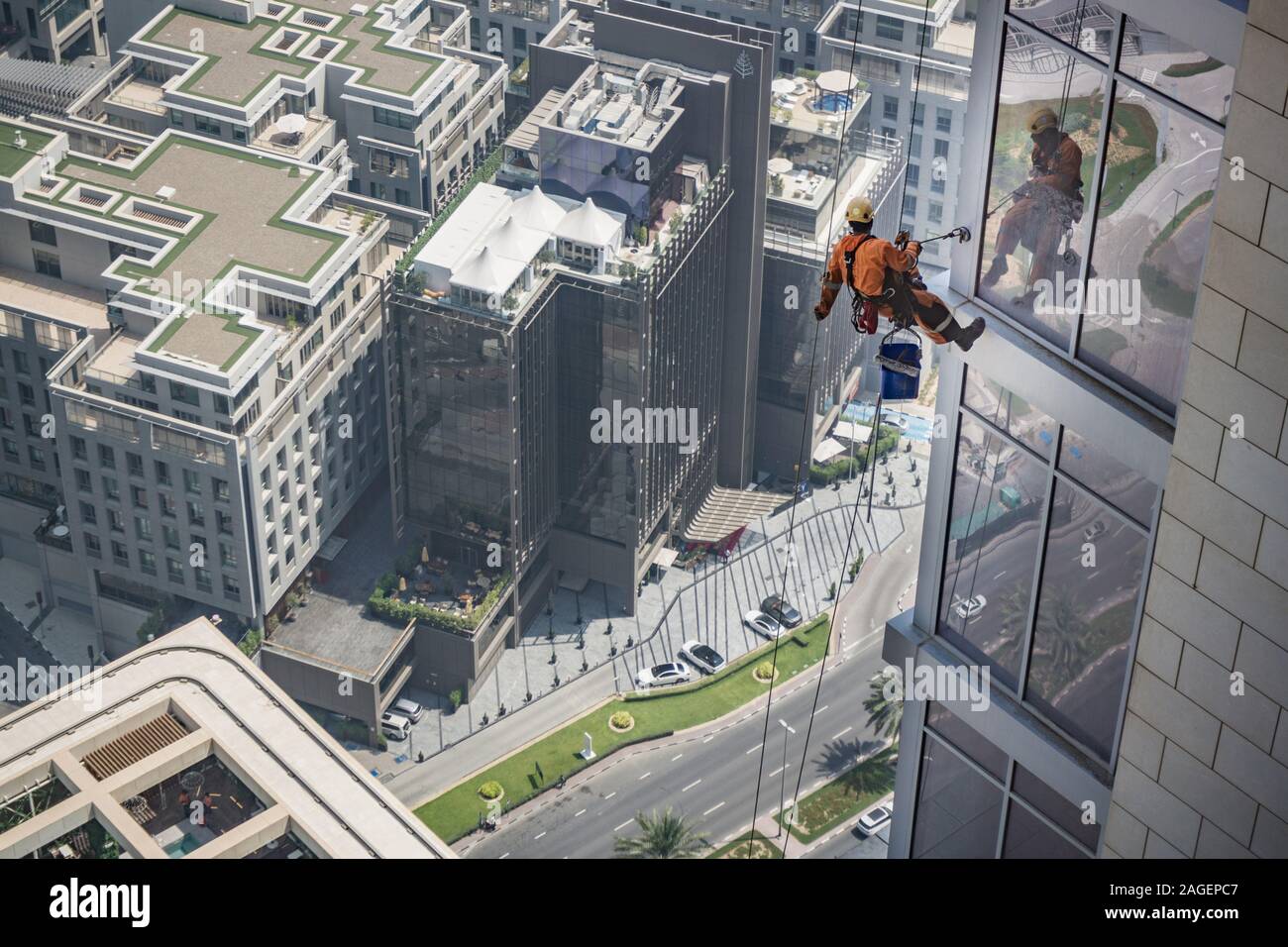 Pulitore per finestre che lavora sulle pareti degli uffici, Dubai, Emirati Arabi Uniti Foto Stock