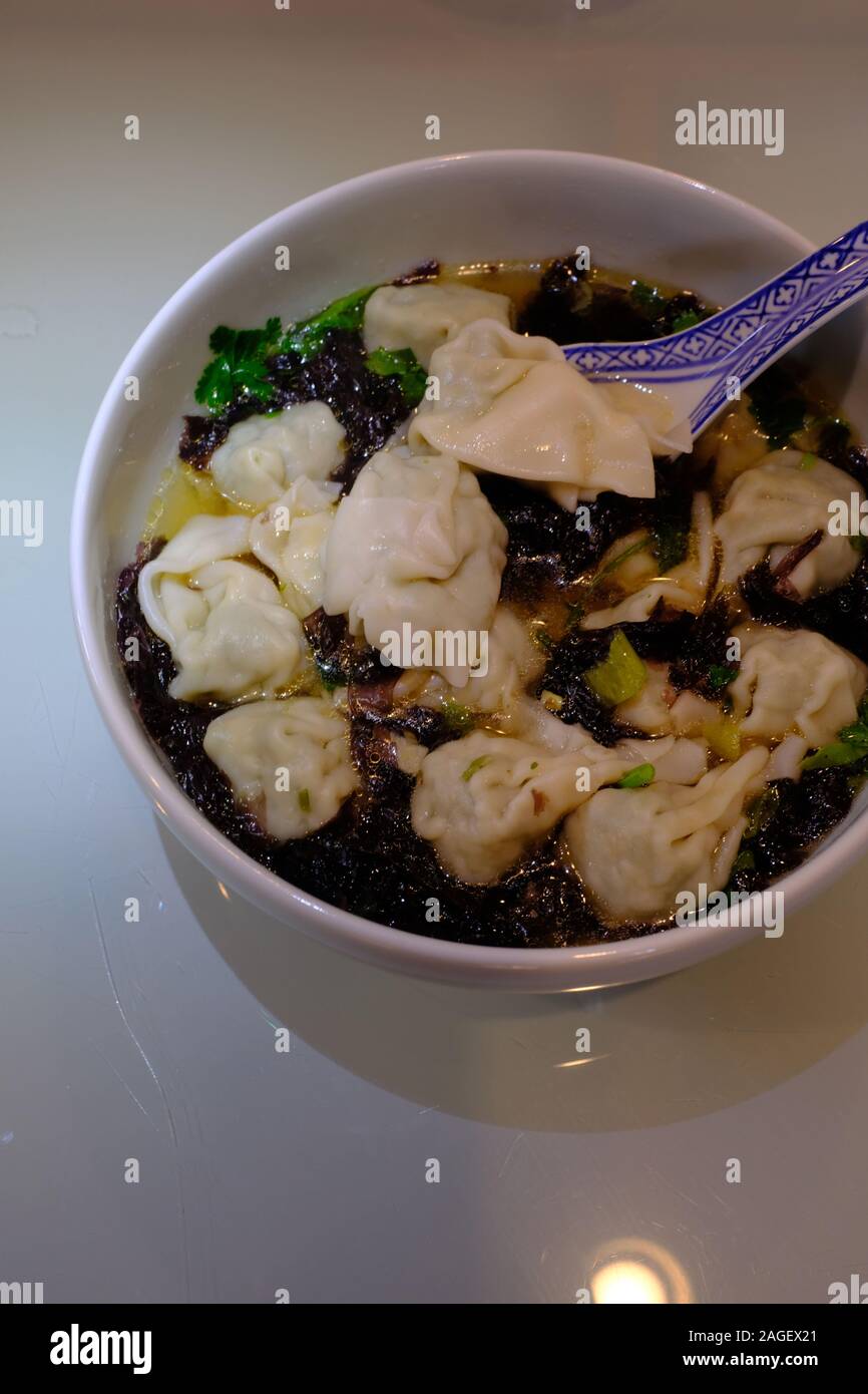 Una ciotola di zuppa Wonton fatta in casa con alghe e verdure verdi. Foto Stock