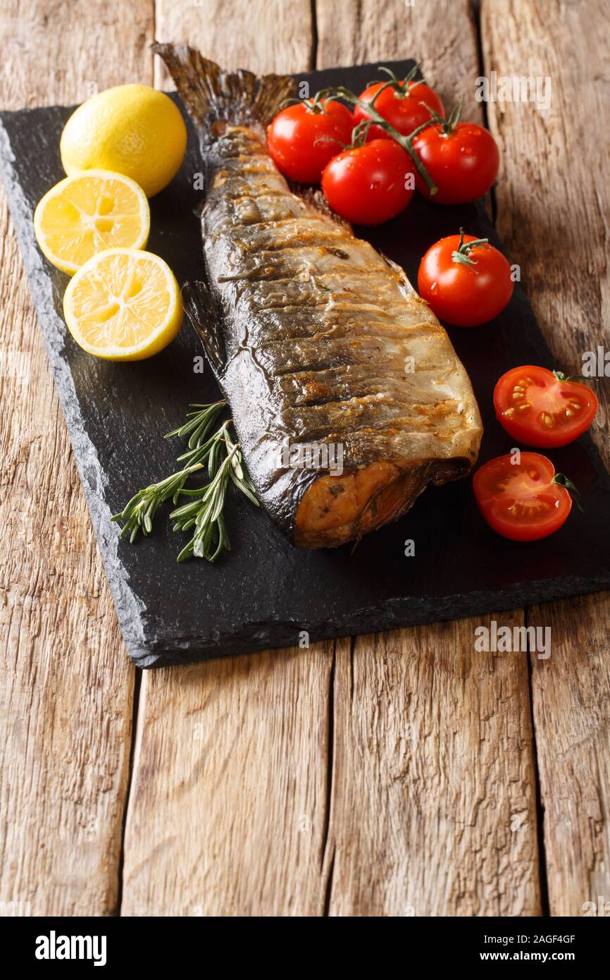 Deliziosa intero grigliato salmone humpback la dieta su una scheda di ardesia sul piano verticale. Foto Stock