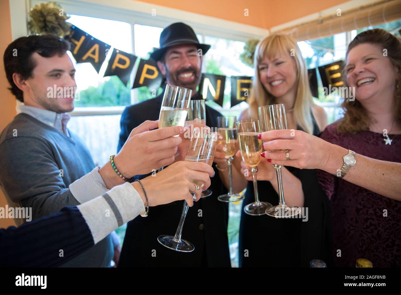 Un gruppo di persone fare un brindisi con champagne a una festa di Capodanno Foto Stock