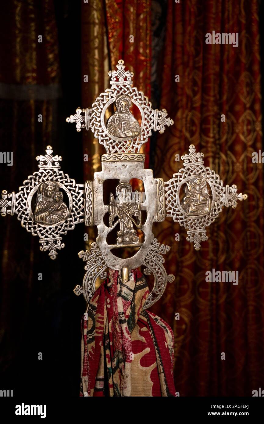 Etiopia, Amhara Region, Lalibela, Arbatu Ensessa, Biblia Chirkos, antiche rocce scavate chiesa, sacerdote mano azienda ornati in fusione di bronzo di preghiera ci trasversale Foto Stock