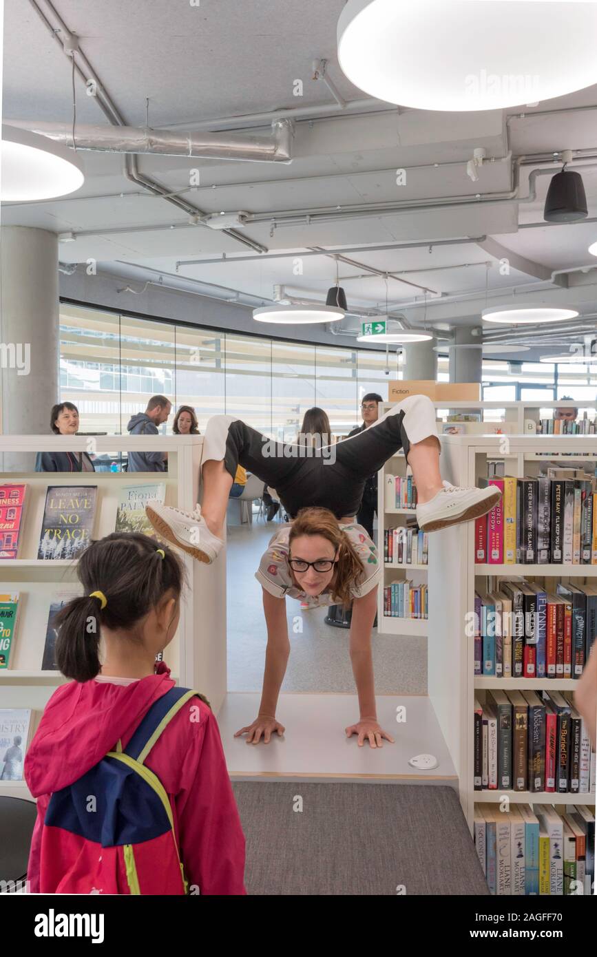 10 NOV 2019: Un contortionist intrattiene i bambini presso l'apertura del nuovo edificio della Borsa e la città di Sydney Libreria nel Darling Square, Sydney Foto Stock