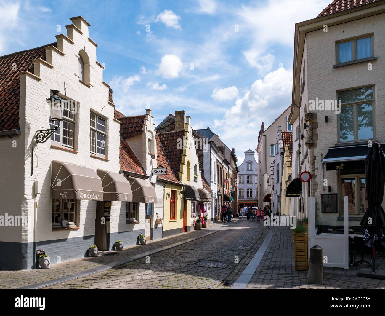 Scena di strada di Walstraat con negozi e ristoranti a Bruges, Belgio Foto Stock