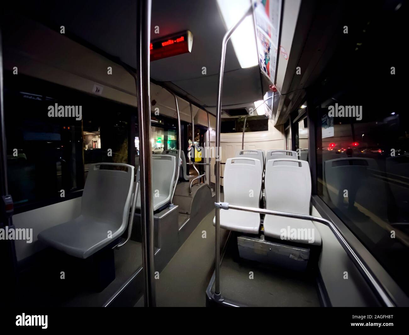 Interno di un trasporto pubblico bus con vuoto posti in grigio e non di passeggeri. Trasporti e mobilità urbana. Ampia angolazione Foto Stock