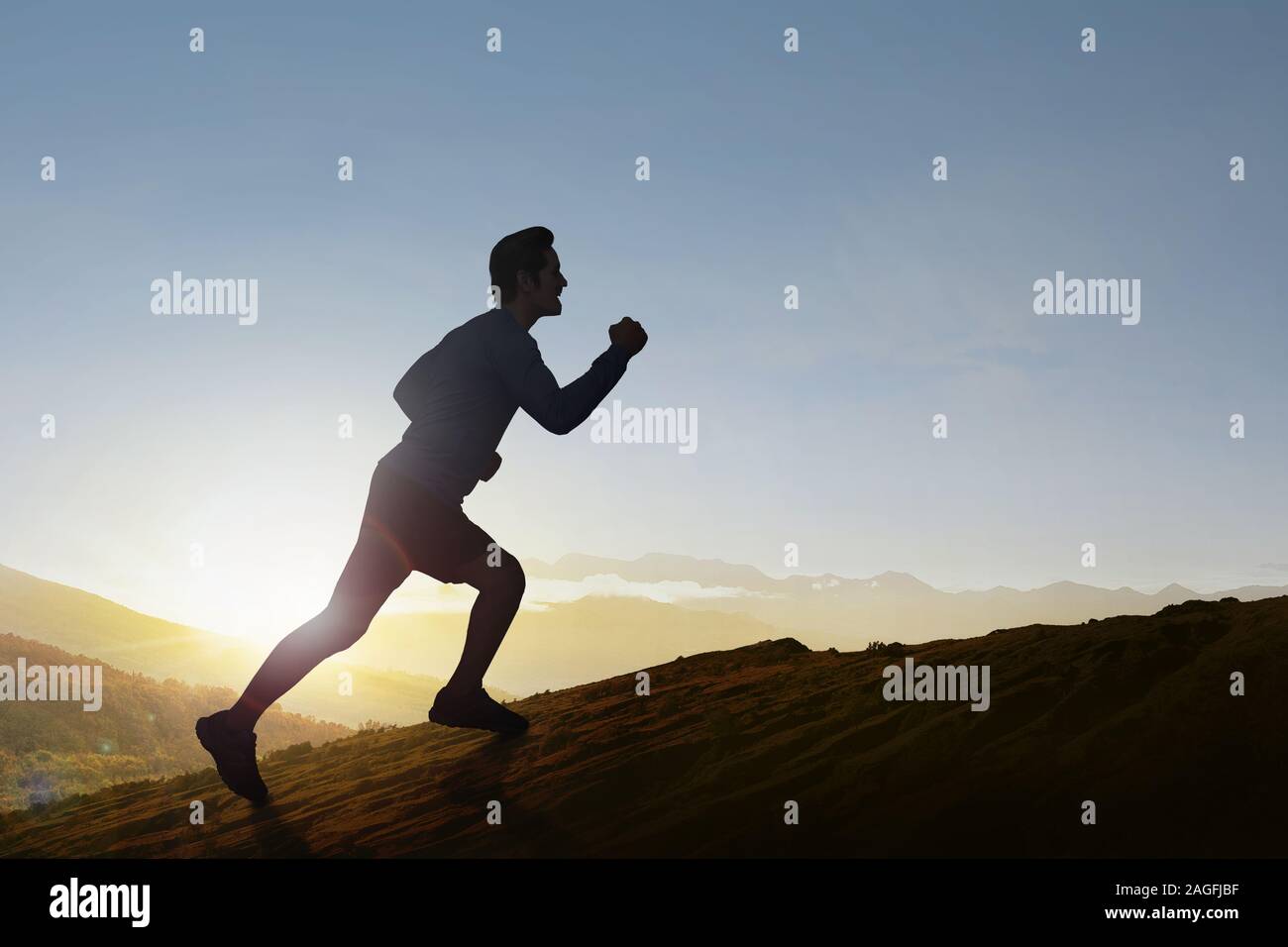 Asian runner uomo correre su per la montagna con un cielo blu sullo sfondo Foto Stock