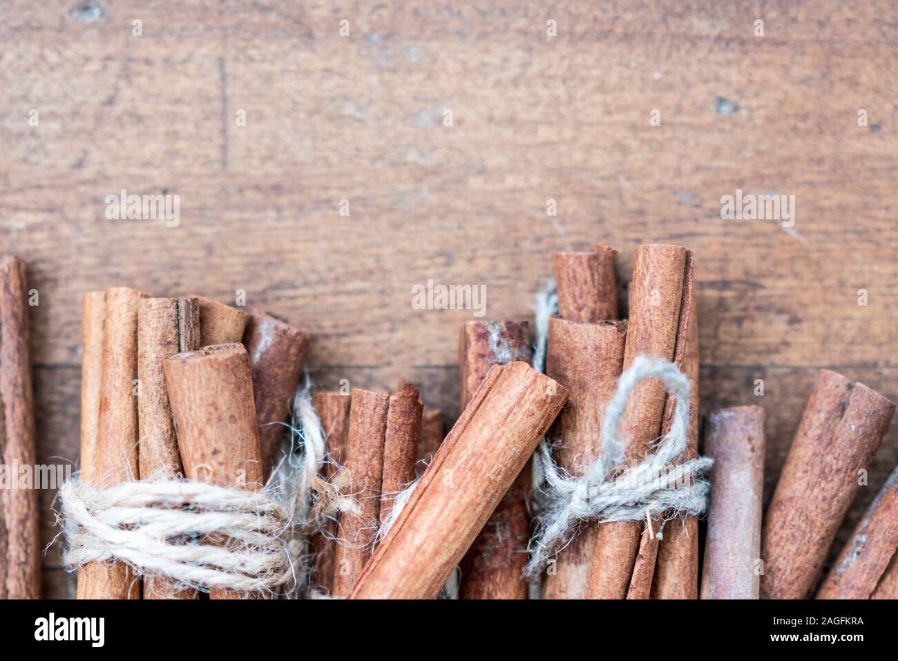 Bastoncini di cannella e pasto close up su sfondo di legno. Natale cornice decorativa di bastoncini di cannella spice. Vista dall'alto. Foto Stock