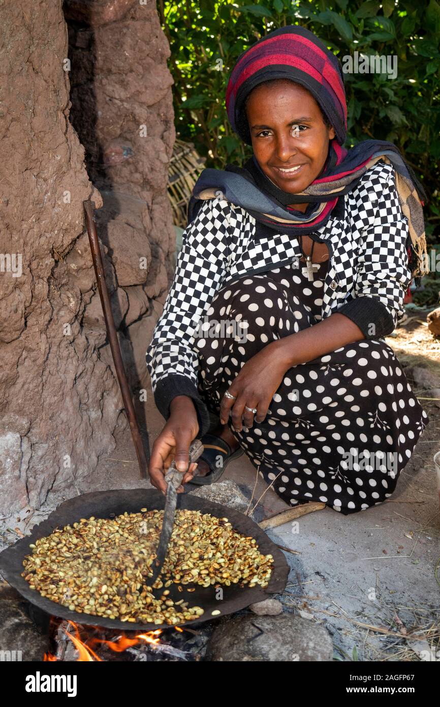 Etiopia, Amhara Region, Lalibela, città storica, donna fresco di tostatura i chicchi di caffè per rendere la buna Foto Stock