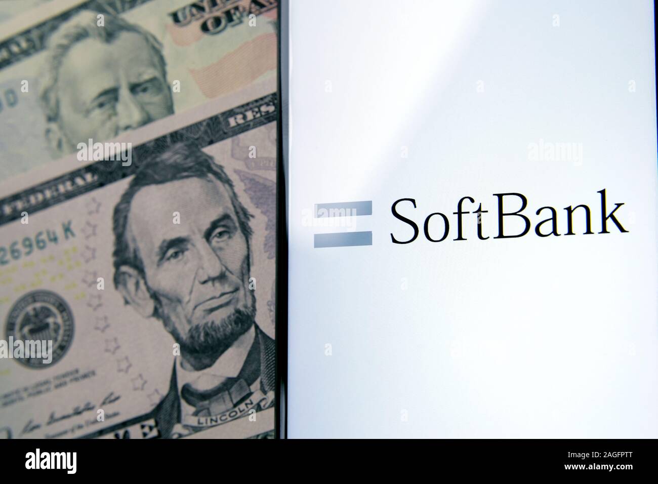 SoftBank logo su uno schermo bianco e dollaro banconote accanto ad essa. Foto concettuale per la multinazionale giapponese conglomerato holding. Foto Stock