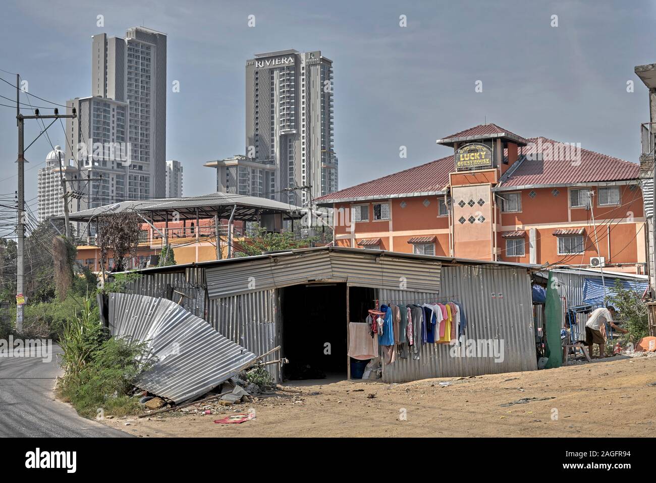 Stile di vita contrastante. Thailandia povertà stagno dimora shack trascurato da alti alberghi. Thailandia Sud-Est asiatico Foto Stock