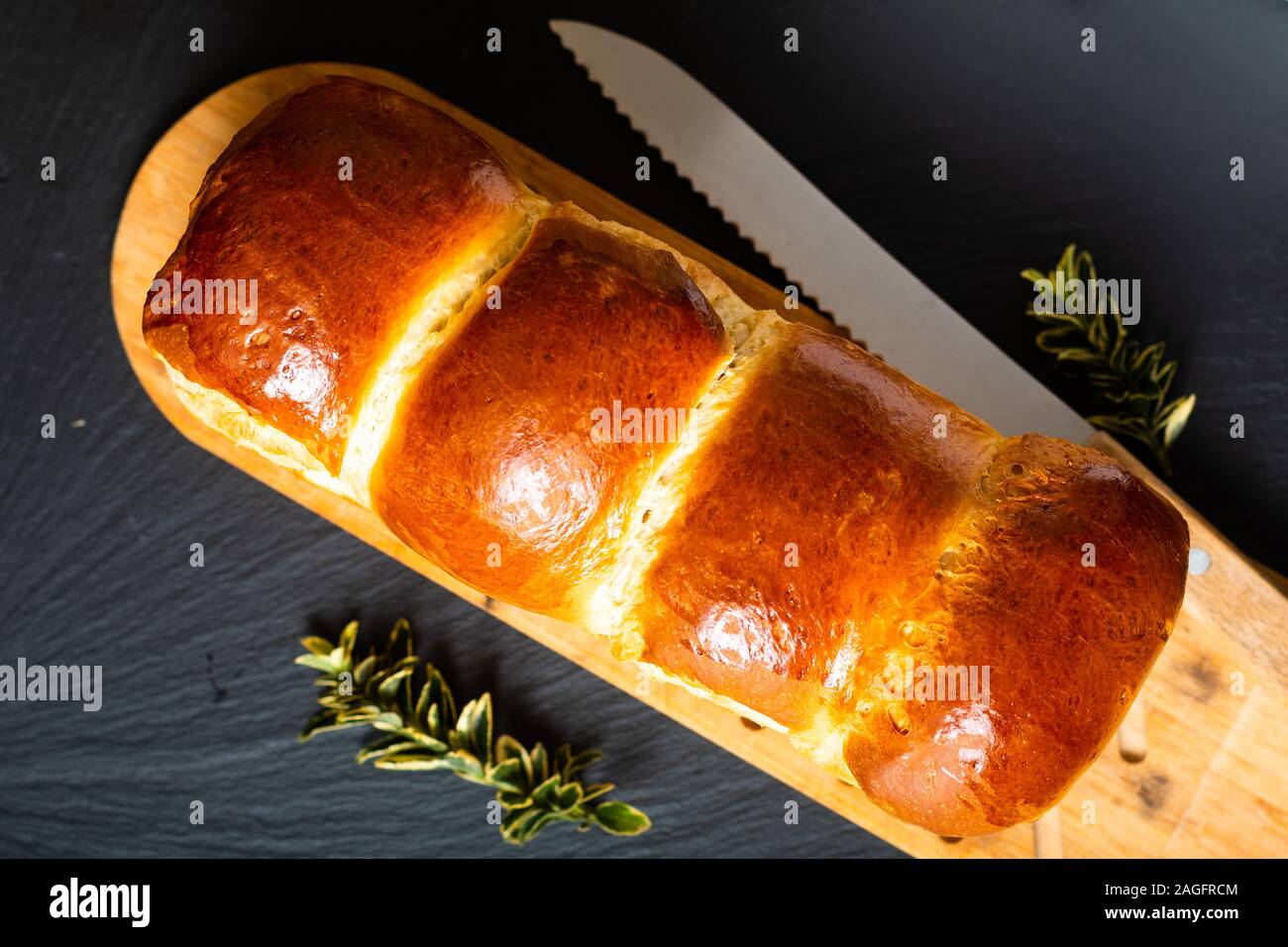 Cibo fatto in casa concetto pane fresco challah treccia o brioche su ardesia nera pietra con spazio di copia Foto Stock