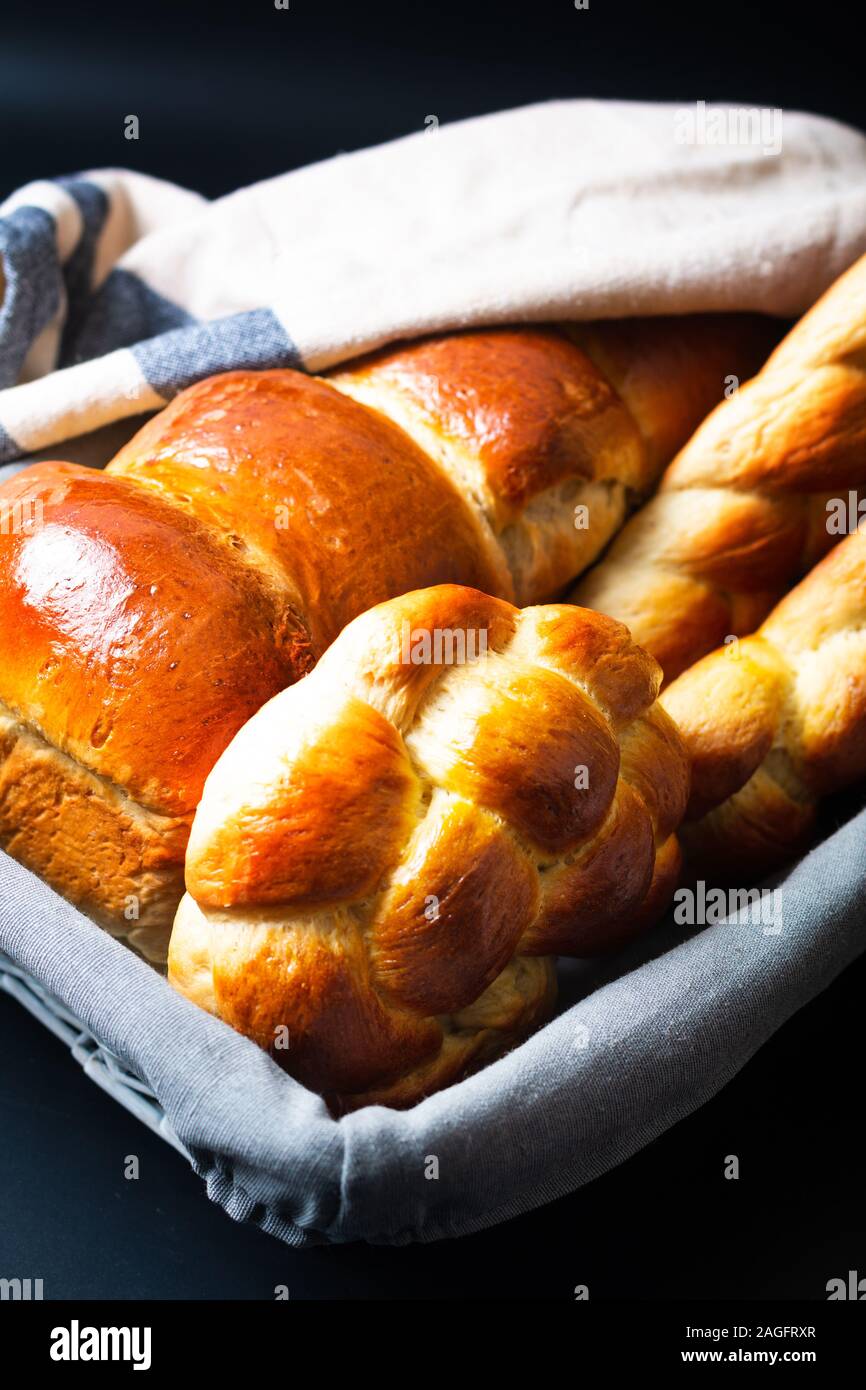 Cibo fatto in casa concetto pane fresco challah treccia o brioche su ardesia nera pietra con spazio di copia Foto Stock