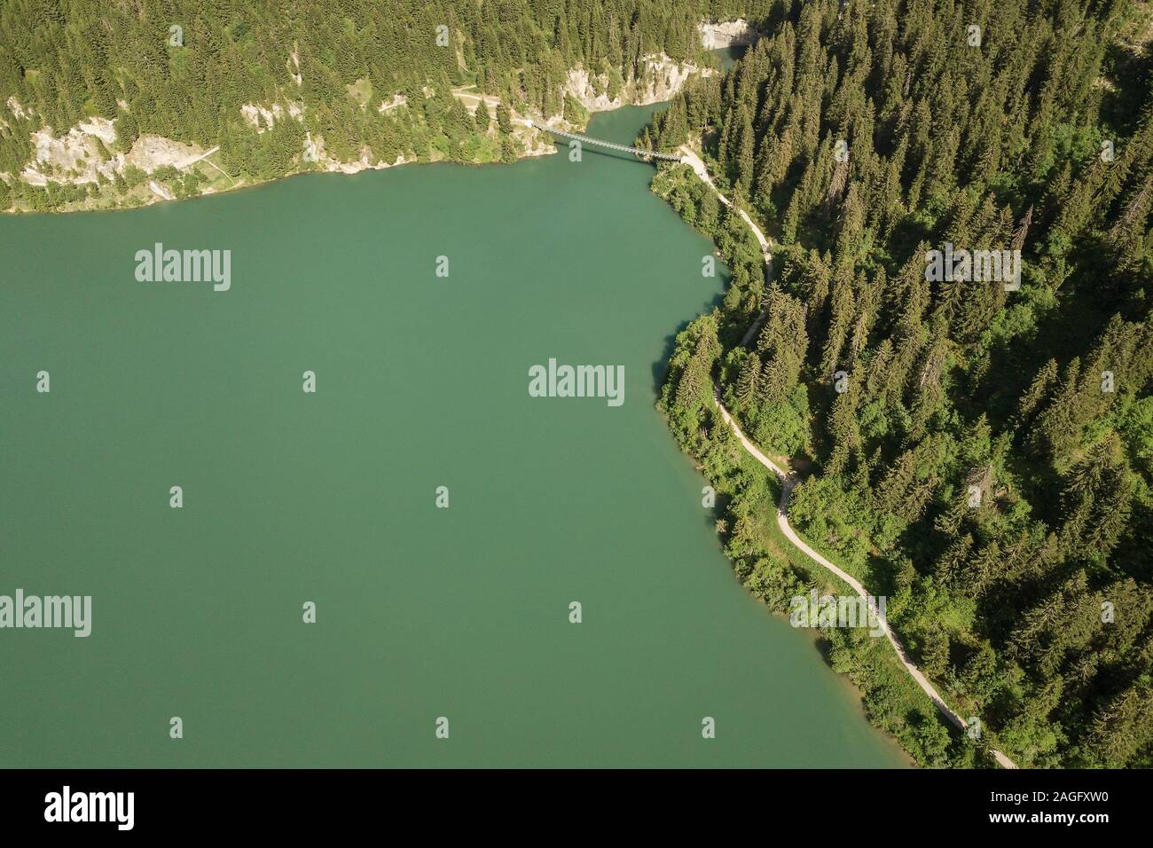 Vista aerea del Lac de Roselend lago nelle Alpi francesi con un percorso a piedi e un ponte pedonale Foto Stock