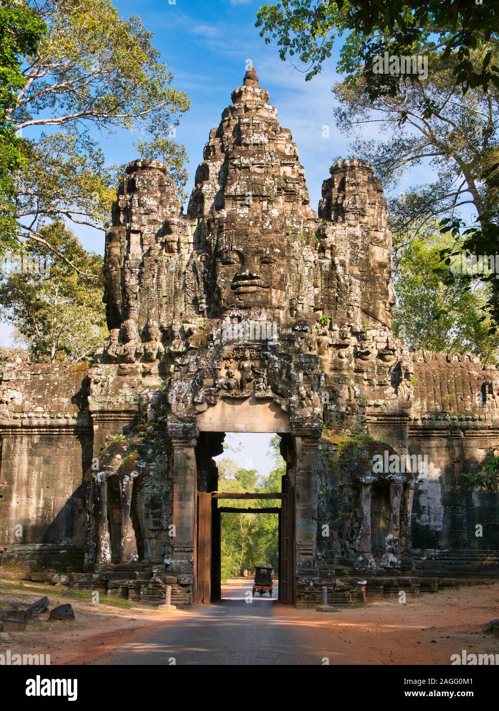 Un tuc-tuc passa sotto la maestosa Porta Vittoria di Angkor Thom vicino a Siem Reap in Cambogia. Foto Stock