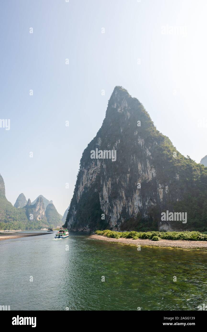 Imbarcazione sulla crociera sul fiume Li e formazione carsica paesaggio di montagna nella nebbia tra Guiling e Yangshuo, provincia di Guangxi, Cina Foto Stock