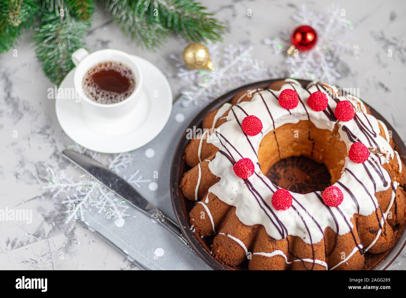 Bella festosa cupcake decorate con panna montata e scoiattoli gelatina di lamponi. Su uno sfondo grigio chiaro sotto il cemento. Capodanno e Natale. C Foto Stock