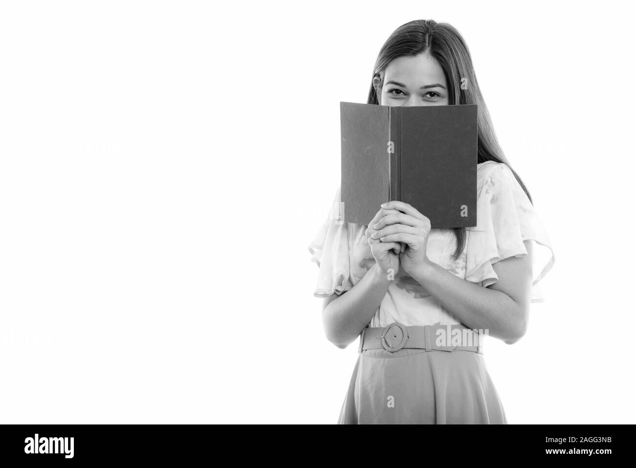 Studio shot del giovane bella donna nascondere dietro il pacco Foto Stock