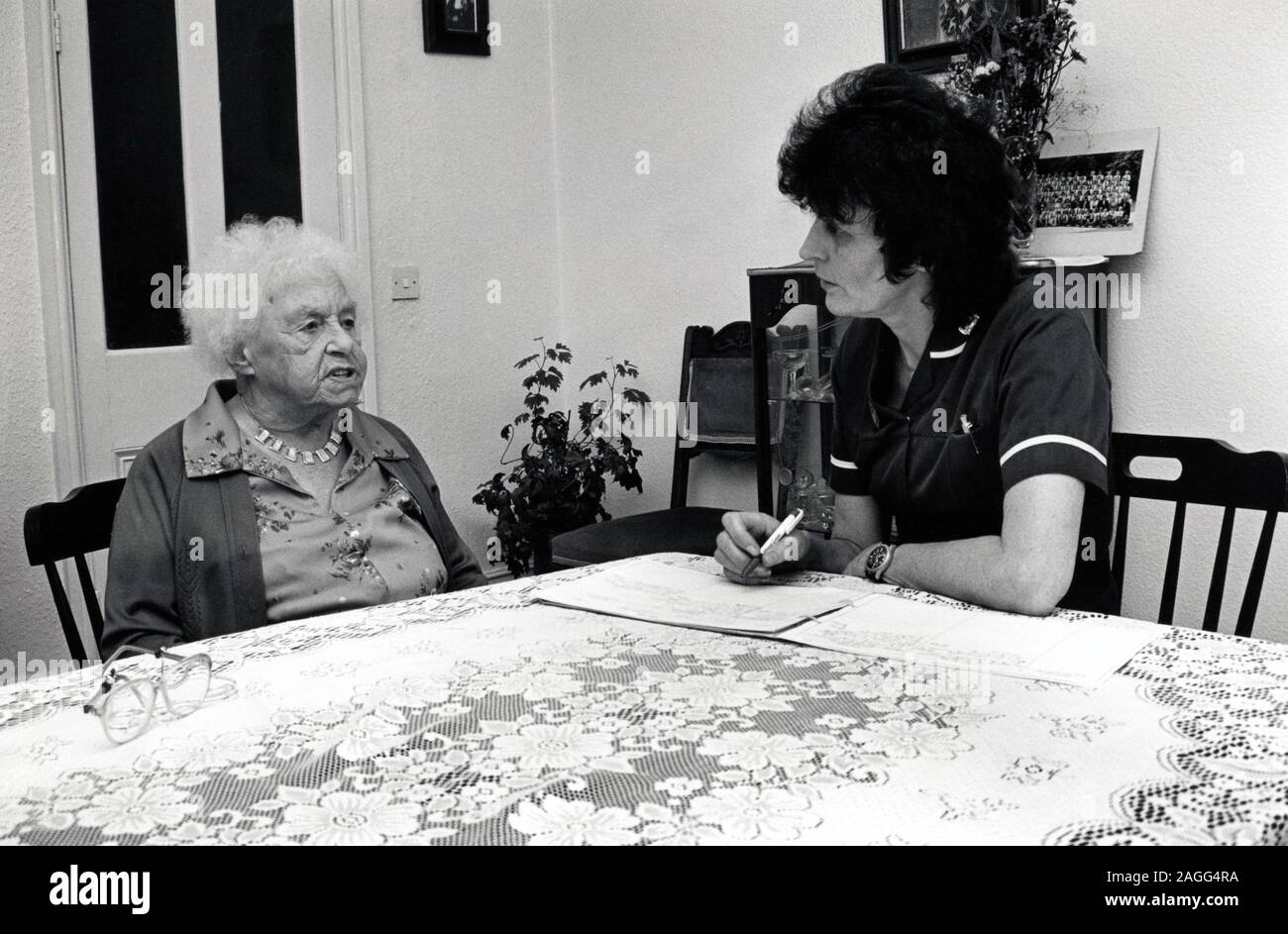 District Nurse visita donna anziana a casa, Nottingham Regno Unito 1990 Foto Stock