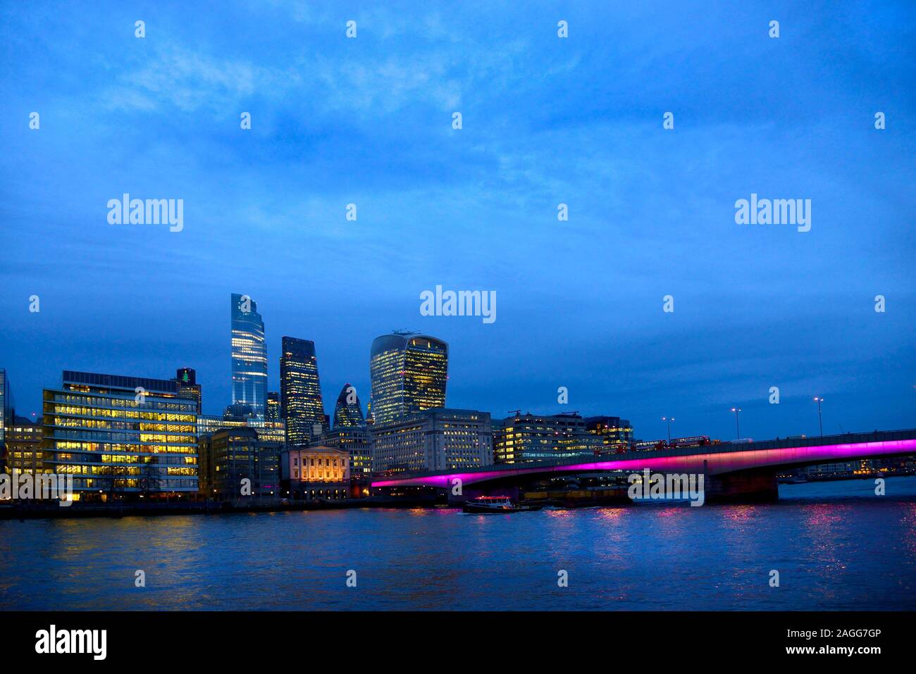 Londra, Inghilterra, Regno Unito. La città di Londra e London Bridge di notte, visto dalla banca del sud Foto Stock