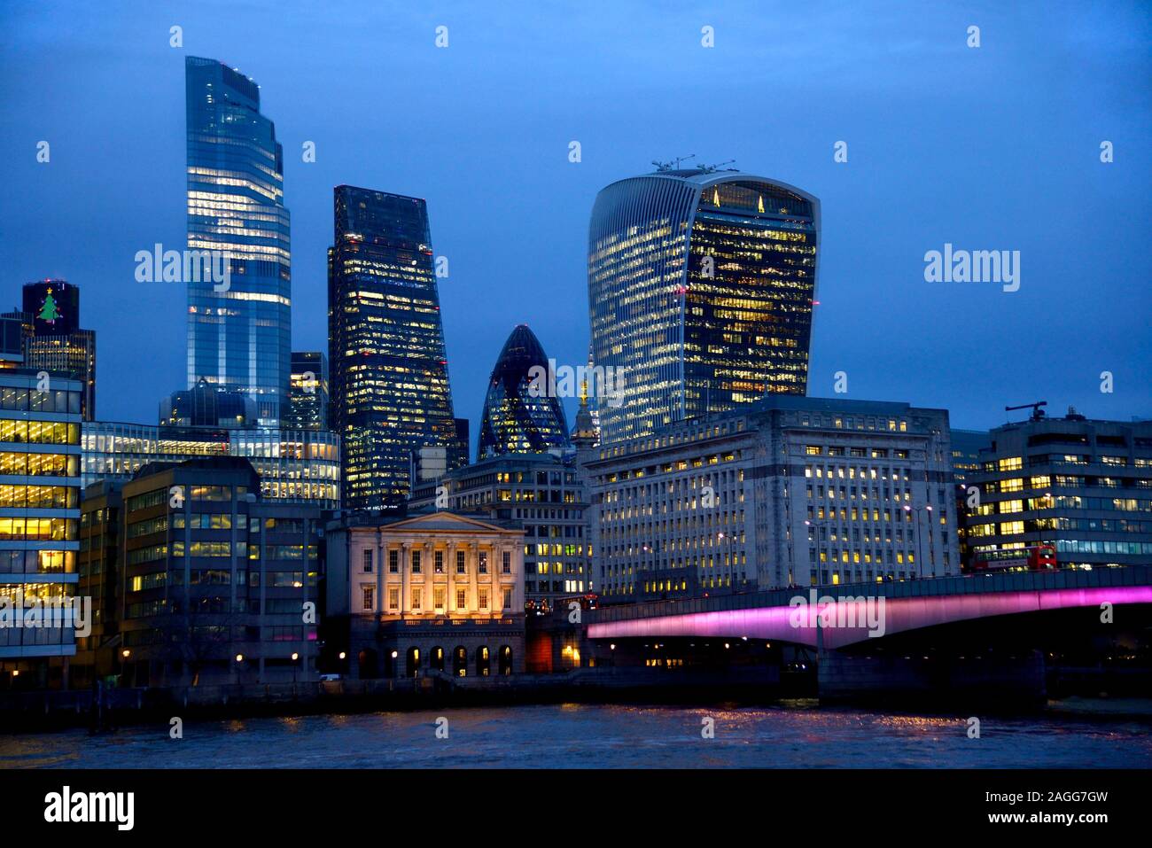 Londra, Inghilterra, Regno Unito. La città di Londra e London Bridge di notte, visto dalla banca del sud Foto Stock