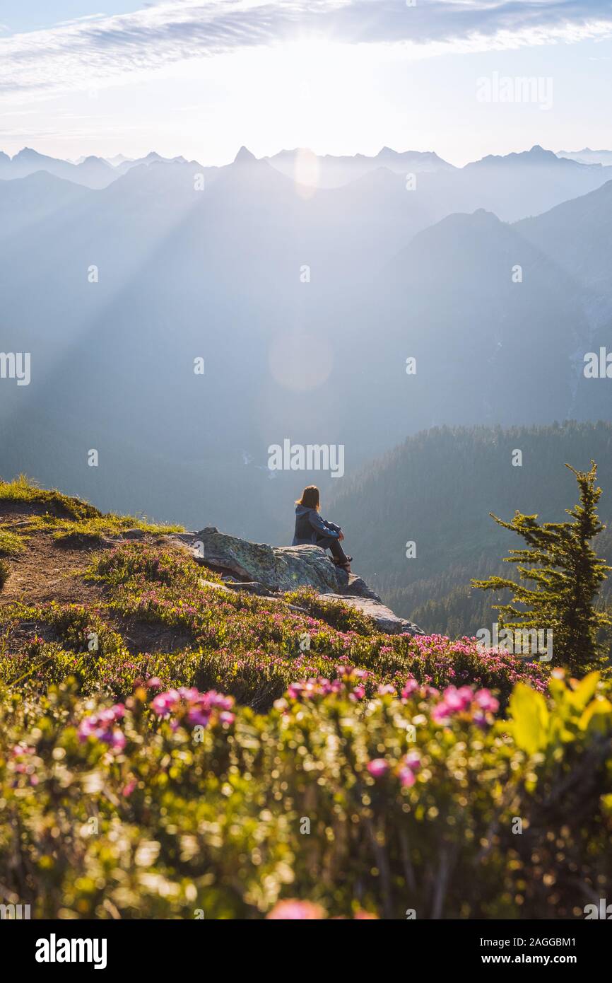 Escursionista femmina godendo il sole sul picco, Winchester Mountain, North Cascades, Washington Foto Stock
