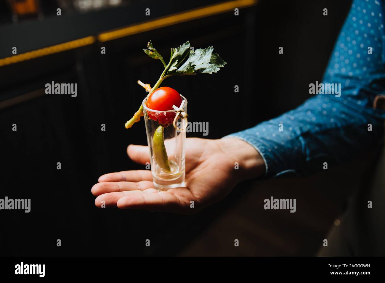 Il cameriere tiene un bicchiere sporco da sotto la bevanda sul suo Palm. Foto Stock