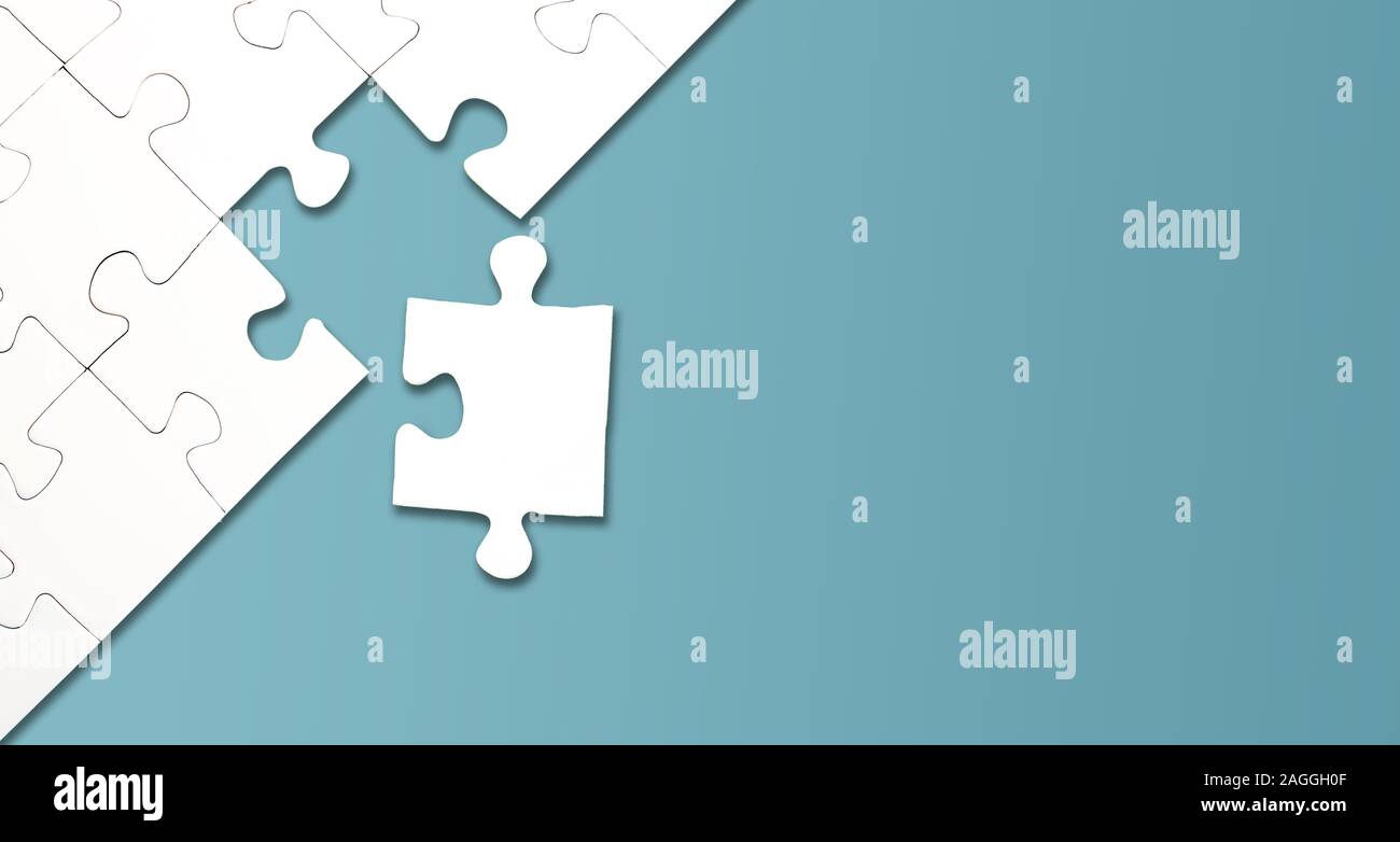 Vista dall'alto di jigsaw puzzle con un pezzo a sinistra su sfondo blu, il completamento di un compito o risolvere un problema di concetto Foto Stock